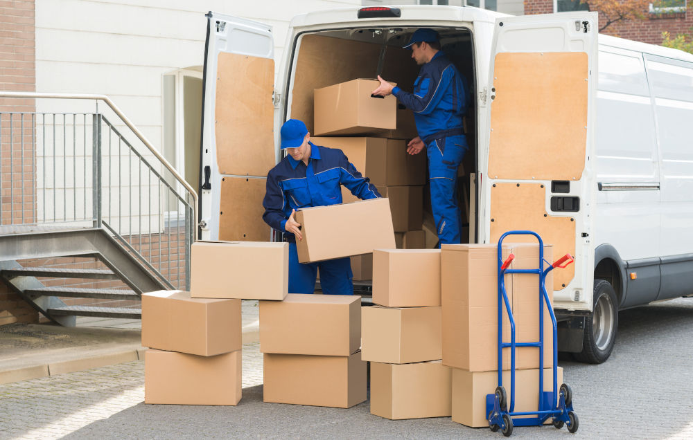 professional movers unloading boxes from a truck on a residential street in Alberta
