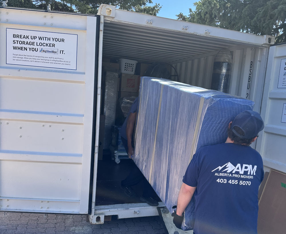 Alberta Pro Movers loading a wrapped mattress into a portable storage container during a residential move in Alberta.