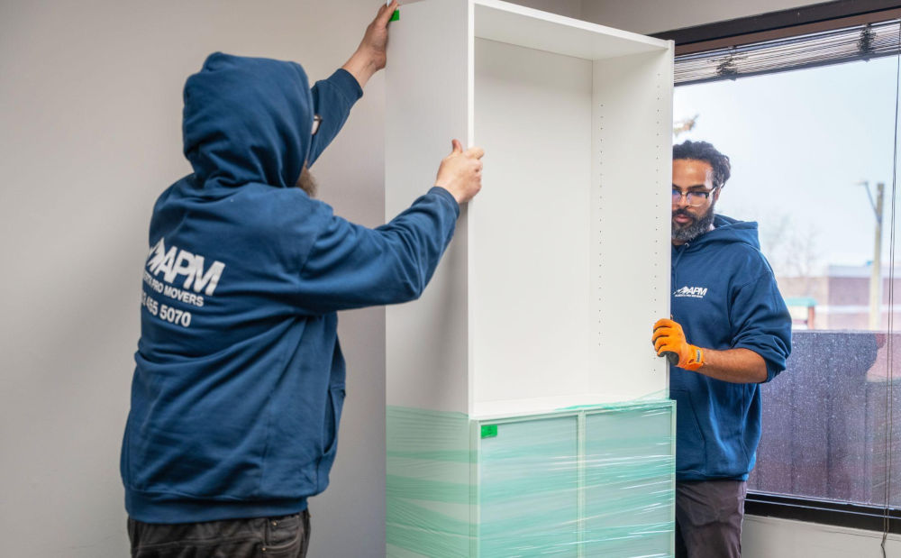 Movers carefully relocating office furniture during a business move
