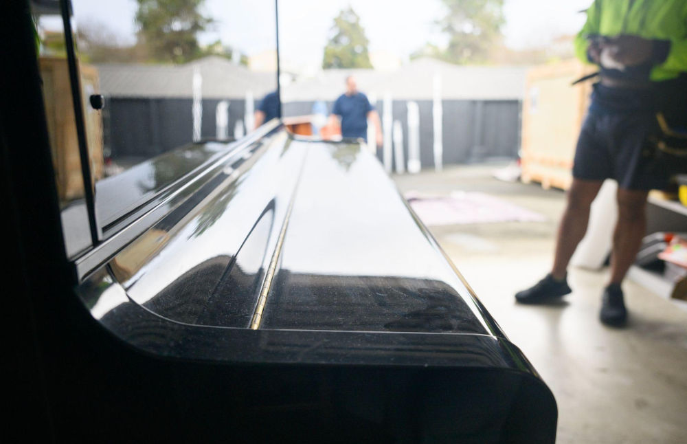 Professional movers loading a piano during a move in Calgary