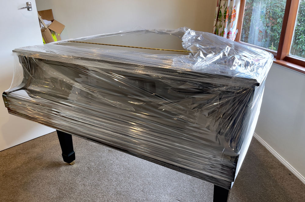 Piano wrapped and protected for professional moving in Calgary